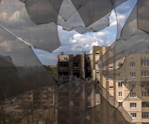 epa10016585 A look through broken window glass shows residential buildings damaged during Russian attacks in Irpin, Ukraine, 16 June 2022. The Ukrainian town of Irpin near Kyiv (Kiev), became a battlefield site when the Russian army attacked the Kyiv region in an attempt to reach Ukraine’s capital. Irpin was heavily shelled, causing death and destruction. At the end of March, when the town was taken back by the Ukrainian army, the mayor of Irpin announced that around 300 civilians and 50 Ukrainian servicemen were killed in Irpin during the Russian attacks. On 24 February Russian troops had invaded Ukraine resulting in fighting, deaths and destruction and a humanitarian crisis in the country.  EPA/ROMAN PILIPEY