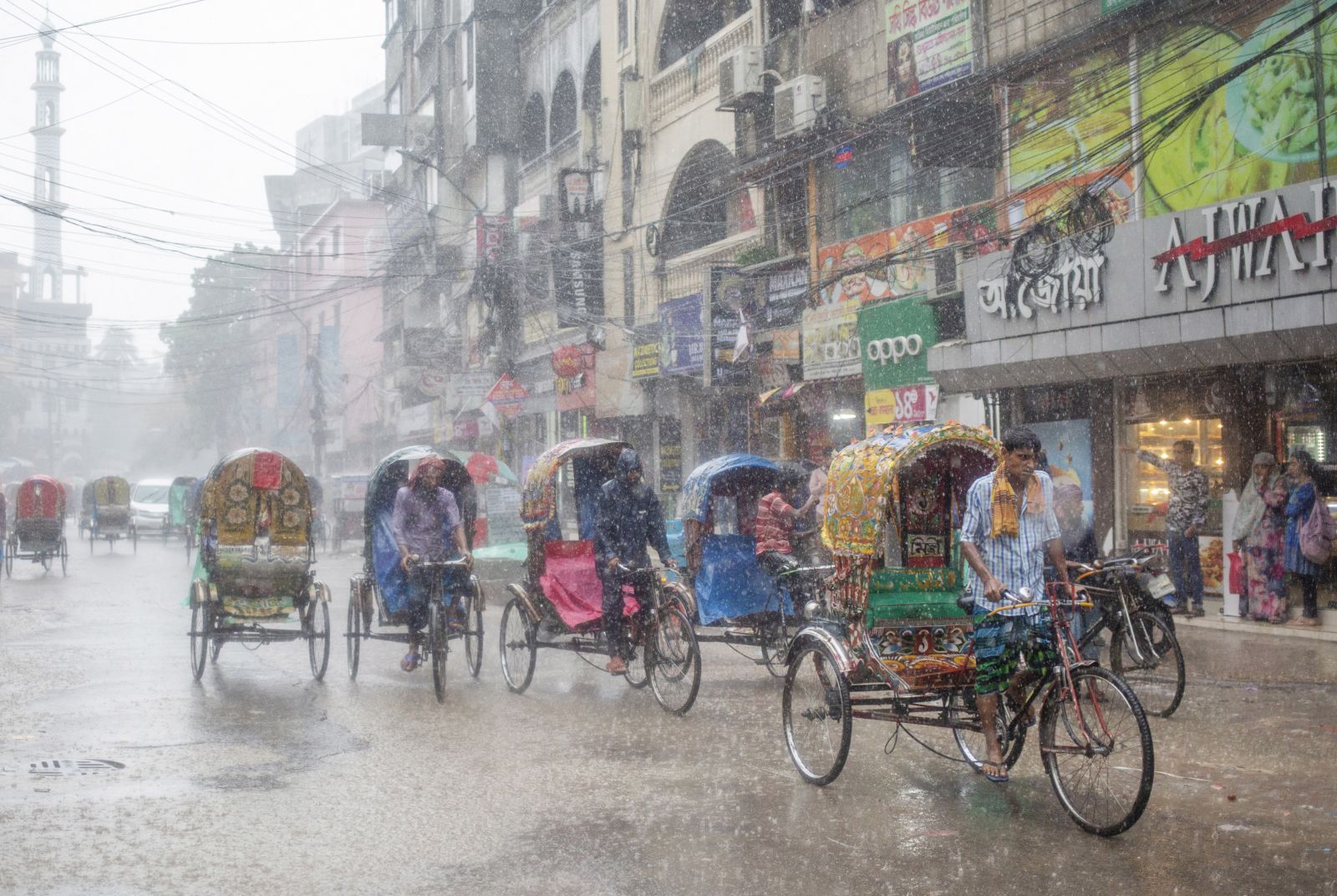 epaselect epa10019536 Rickshaw pullers ride their rickshaws during a rain in Dhaka Bangladesh, 18 June, 2022. Monsoon rains are expected over Bangladesh and over North Bay. The Flood Forecasting and Warning Centre warned that the floods could hit 14 districts in the northern region of Bangladesh in the next two days.  EPA/MONIRUL ALAM