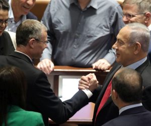 epa10027196 Leader of the opposition and former Israeli Prime Minister Benjamin Netanyahu (R) shakes hands with Yariv Levin (L) during a voting session to dissolve the government in the Knesset Plenum, the Israeli Parliament, in Jerusalem, Israel, 22 June 2022. Parliament members are voting for the law to dissolve the government and go to early elections.  EPA/ABIR SULTAN