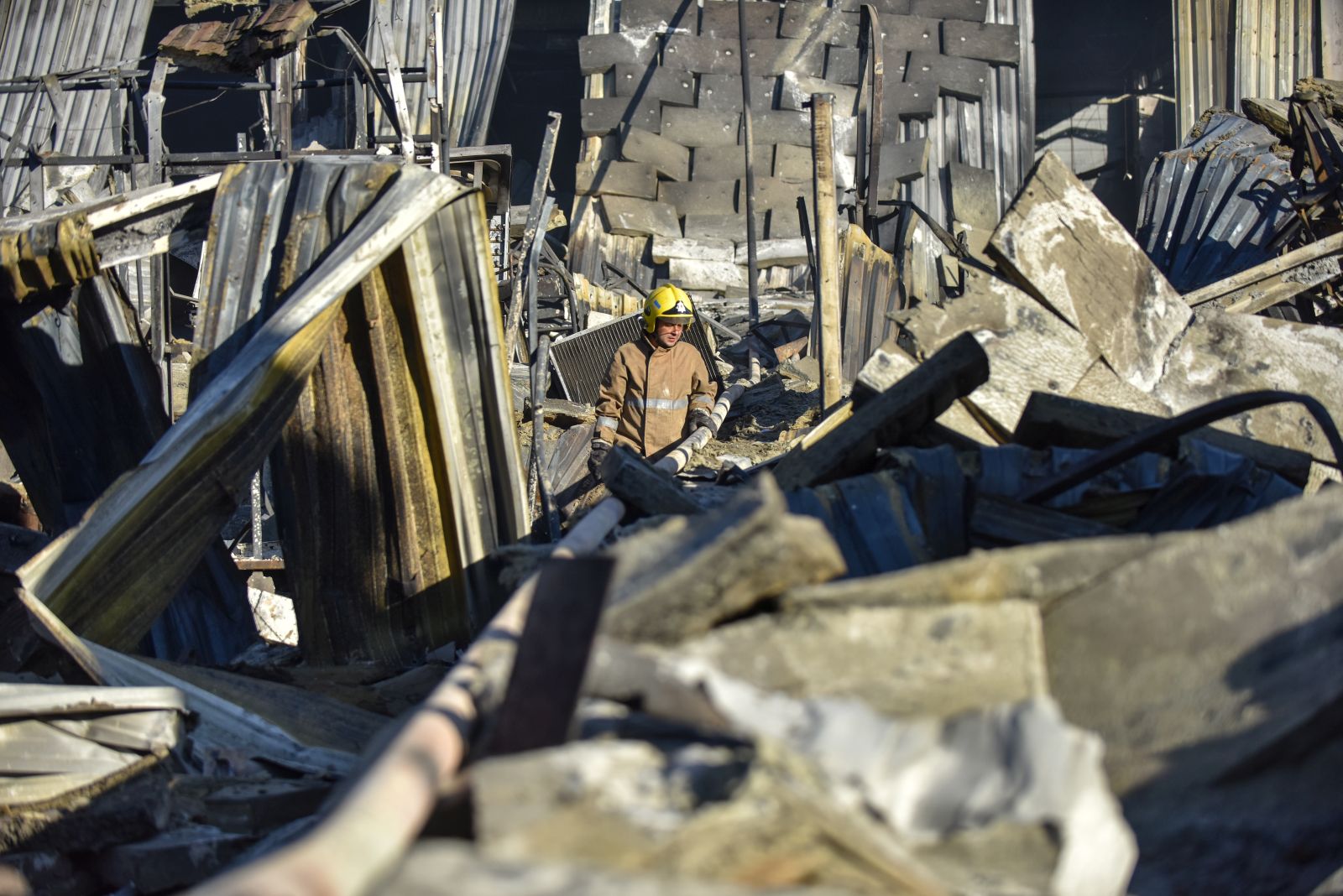 epa10037731 A firefighter works amid the rubble of the destroyed Amstor shopping mall in Kremenchuk, Poltava Oblast, Ukraine, 28 June 2022. At least eighteen bodies were found dead at the scene, the State Emergency Service (SES) of Ukraine said in a Telegram post, and at least 58 injured following Russian airstrikes on the crowded shopping mall. The one-story building of a shopping center was hit by Russian rockets on 27 June in the afternoon.  EPA/OLEG PETRASYUK