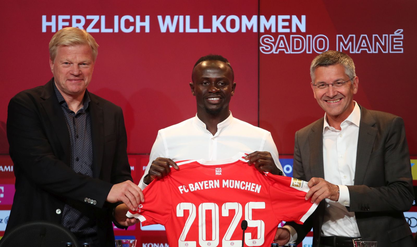 epa10027878 Sadio Mane (C) poses with the team's shirt with Bayern Munich CEO Oliver Kahn (L) and Bayern Munich Chairman of the Supervisory Board Herbert Hainer at a press conference during his presentation as a new signing for Bayern Munich, Munich, 22 June 2022. The Senegalese international left Liverpool FC after six years to join the German champions on a three-year contract.  EPA/MARTIN DIVISEK