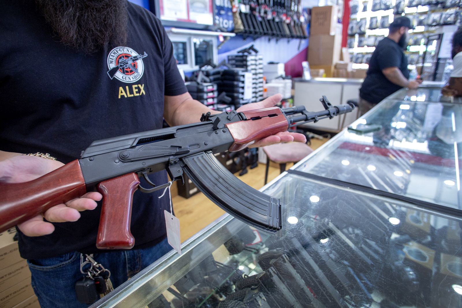 epa10028672 A worker at the Miami Guns Store and Range shows an AK-47 gun, in Hialeah, Florida, USA, 22 June 2022. On 21 June a bipartisan group of US senators released the Bipartisan Safer Communities Act to control gun violence, which if passed by Congress, could become the most significant renovation of the nation's gun laws in decades.  EPA/CRISTOBAL HERRERA-ULASHKEVICH