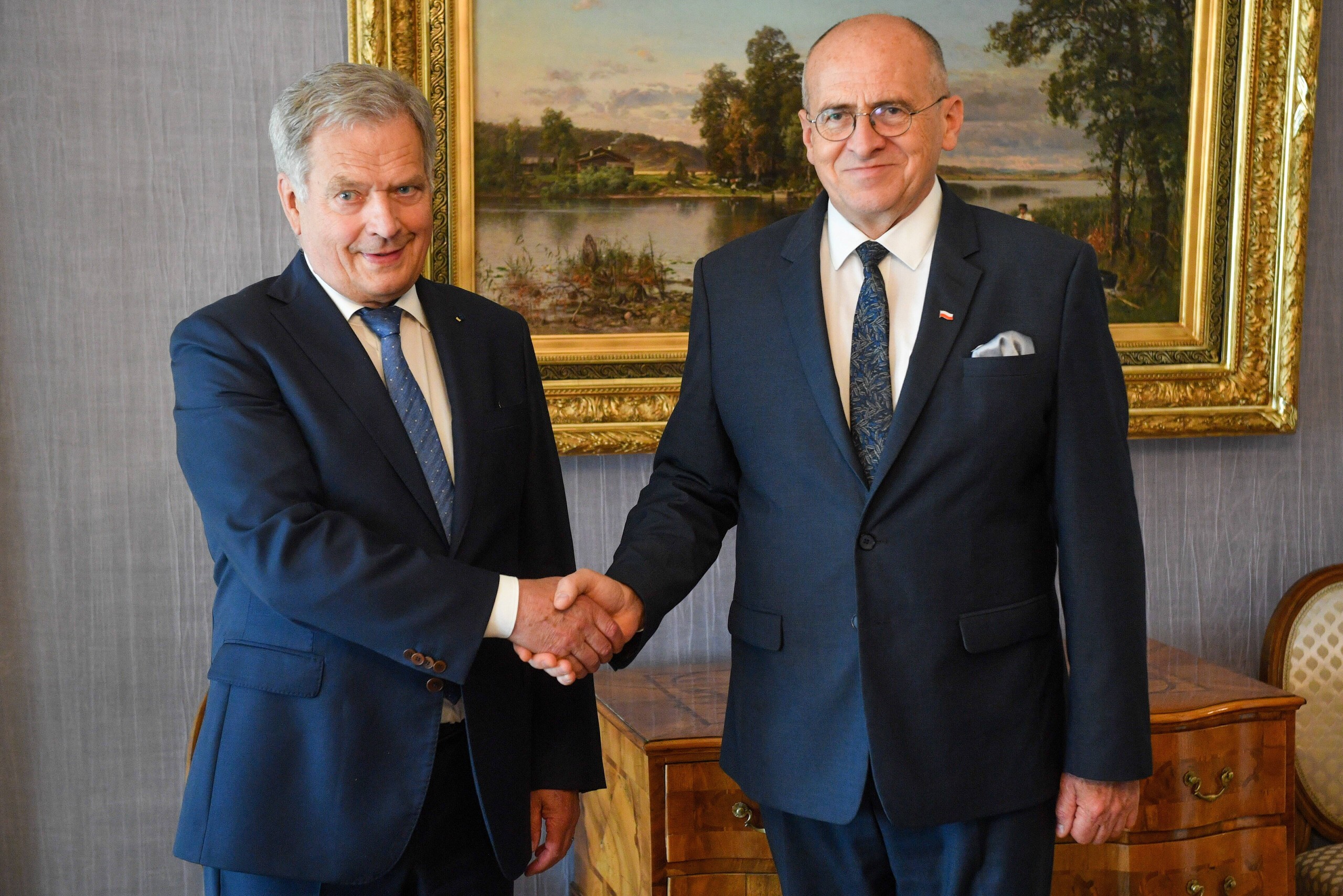 epa10045191 Polish Minister of Foreign Affairs Zbigniew Rau (R) and the President of Finland, Sauli Niinisto (L), shake hands before their meeting in Helsinki, Finland, 01 July 2022. Minister Rau is on a one-day visit to Finland.  EPA/RADEK PIETRUSZKA POLAND OUT
