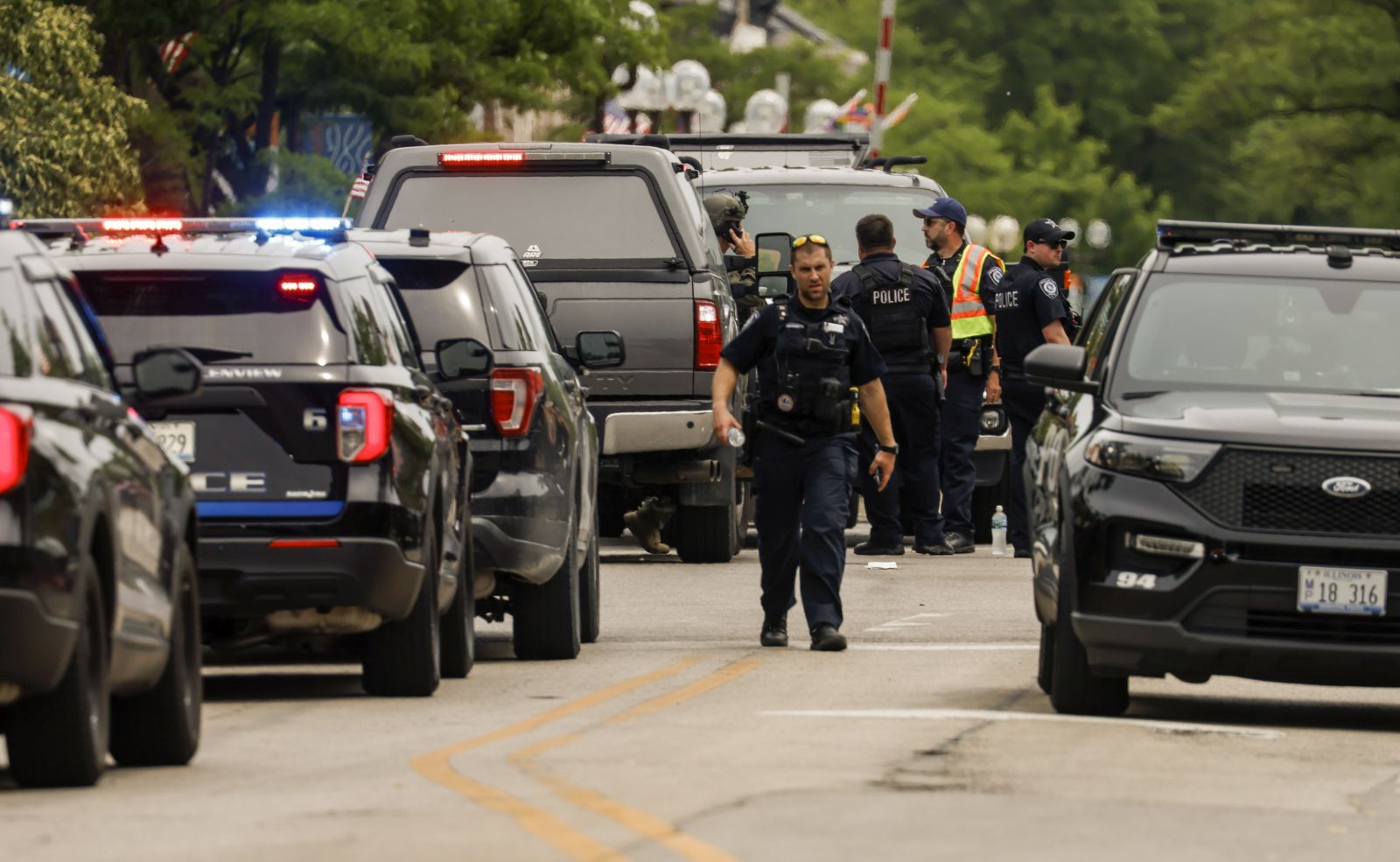 epa10052339 Law enforcement officers investigate the scene of a mass shooting at a 4th of July celebration and parade in Highland Park, Illinois, USA, 04 July 2022. A gunman opened fire as people gathered to watch a Fourth of July parade in Highland Park, Illinois, killing at least six people and injuring dozens.  EPA/TANNEN MAURY
