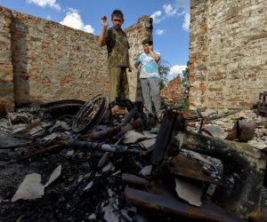 epaselect epa10052555 Ihor (L) and Olga (R) stand on the remains of their house in Kukhari village, Kyiv (Kiev) region, Ukraine, 04 July 2022. Igor Zaritsky (38) and Olga Zaritska (36) with their three children Julia (15), Yehor (9), and Vita (2), live in makeshift accommodation after their house was destroyed by shelling in March 2022. The family is now waiting for a trailer to be set up. Russian troops entered Ukraine on 24 February resulting in fighting and destruction in the country and triggering a series of severe economic sanctions on Russia by Western countries.  EPA/OLEG PETRASYUK