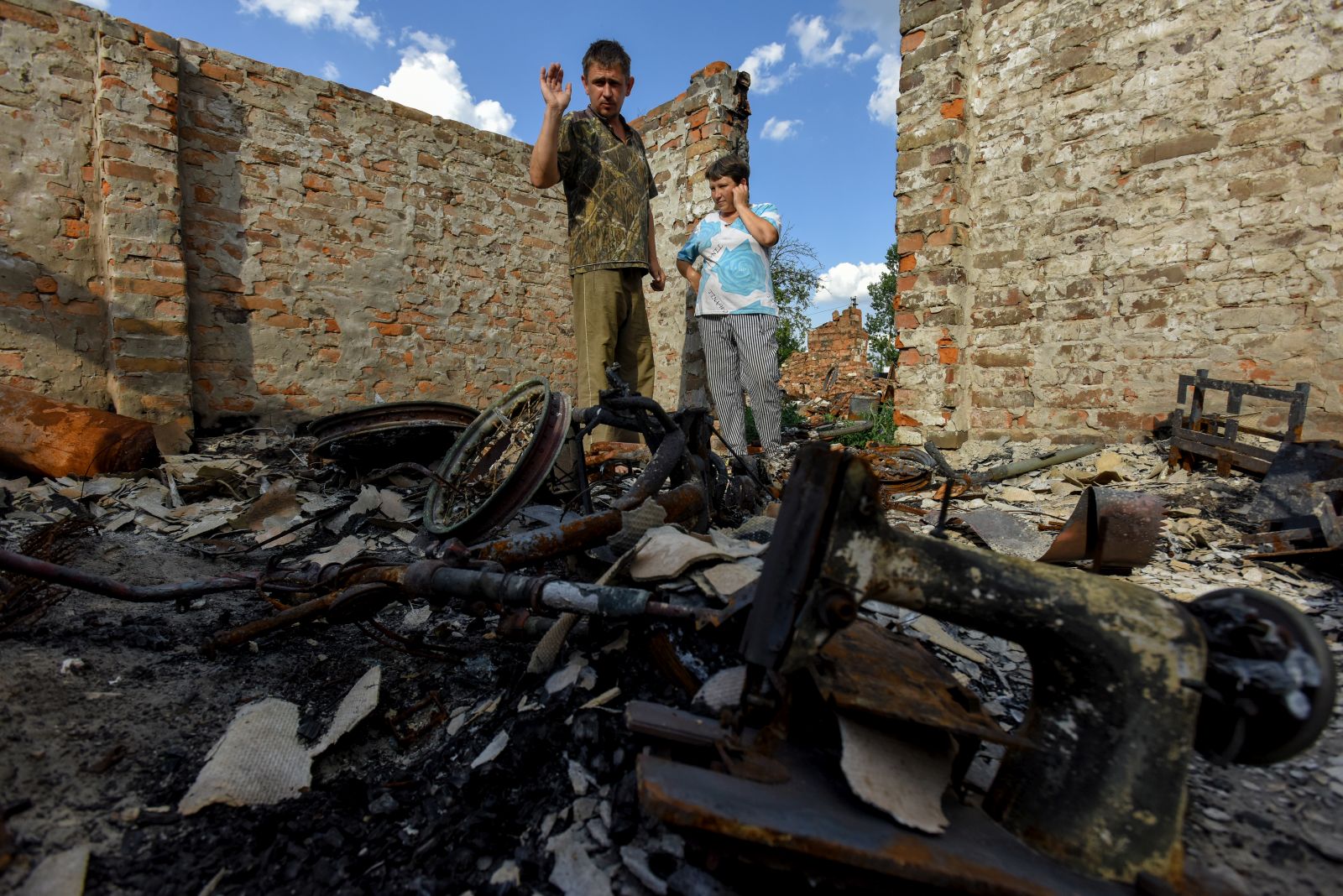 epaselect epa10052555 Ihor (L) and Olga (R) stand on the remains of their house in Kukhari village, Kyiv (Kiev) region, Ukraine, 04 July 2022. Igor Zaritsky (38) and Olga Zaritska (36) with their three children Julia (15), Yehor (9), and Vita (2), live in makeshift accommodation after their house was destroyed by shelling in March 2022. The family is now waiting for a trailer to be set up. Russian troops entered Ukraine on 24 February resulting in fighting and destruction in the country and triggering a series of severe economic sanctions on Russia by Western countries.  EPA/OLEG PETRASYUK
