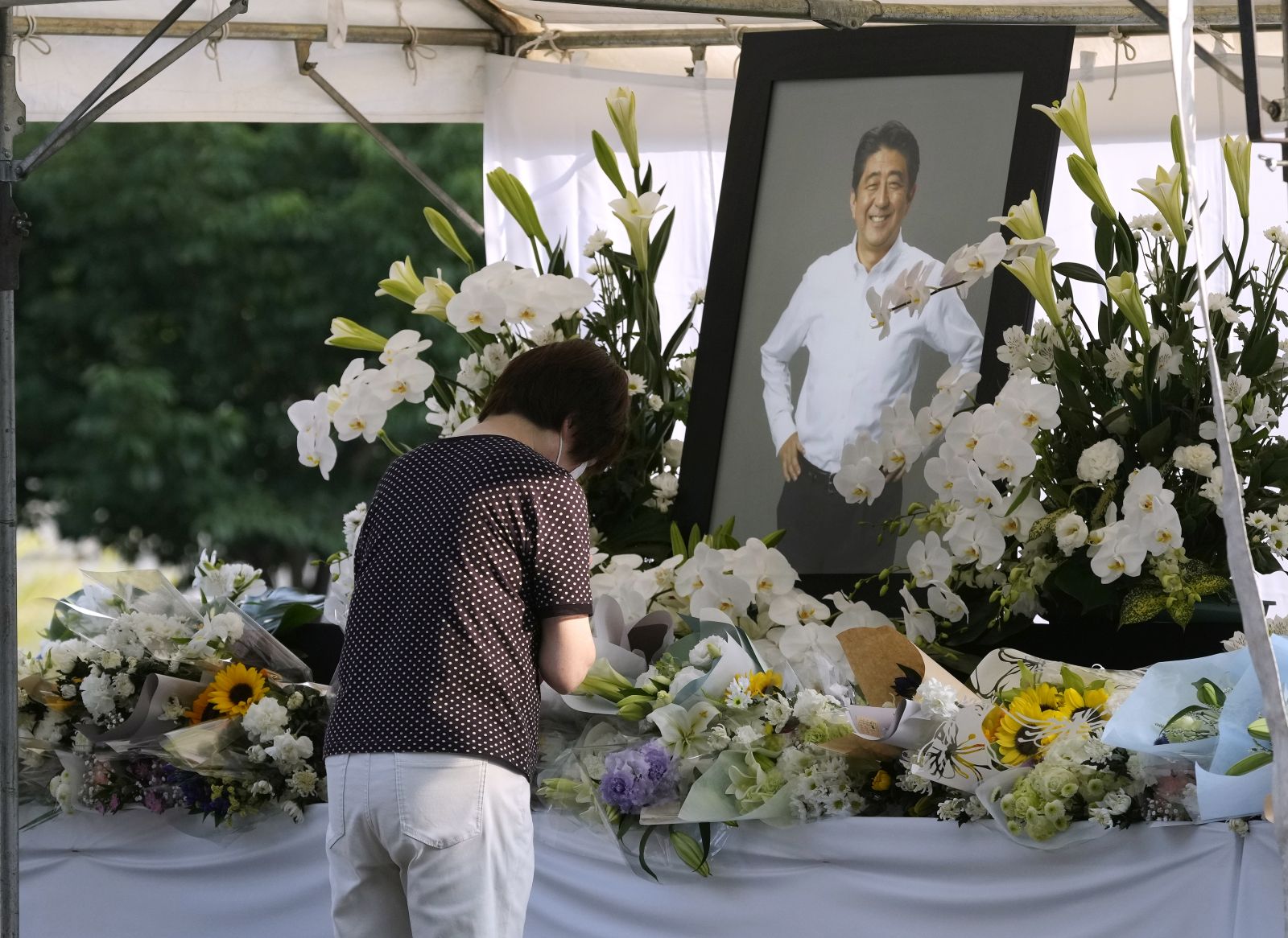 epa10064819 A woman mourner pays floral tribute for former Prime Minister Shinzo Abe at Zojoji Temple, where a private family wake for former is held in Tokyo, Japan, 11 July 2022.  Abe was shot dead on 08 July by a 41-year-old former member of the Japan Maritime Self-Defense Force, in Nara, western Japan, during an Upper House election campaign to support a candidate of his ruling party.  EPA/KIMIMASA MAYAMA