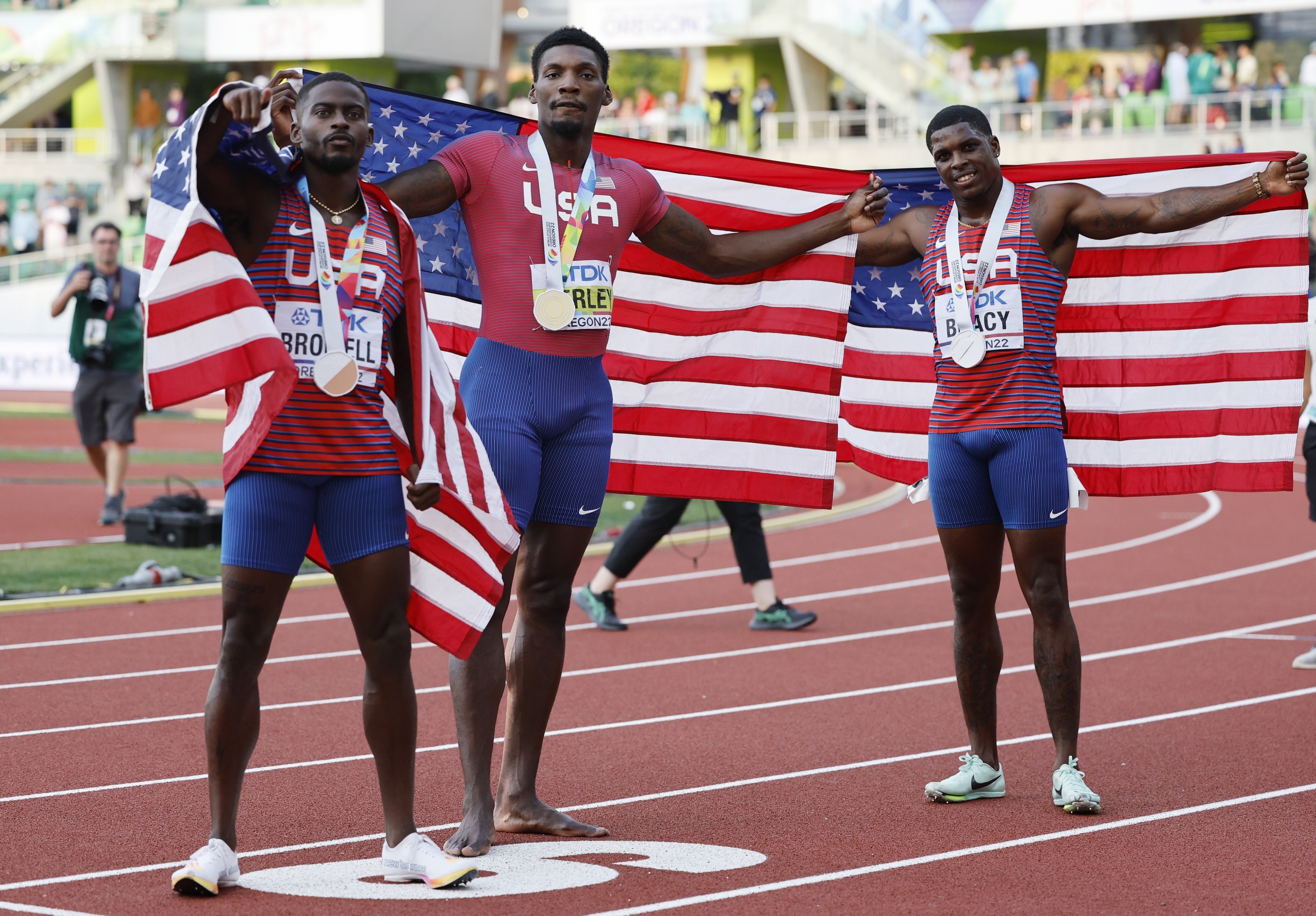epa10075583 Winner Fred Kerley (C) of the US, second place Marvin Bracy (R) of the US and third placed Trayvon Bromell celebrate after the men's 100m final at the World Athletics Championships Oregon22 at Hayward Field in Eugene, Oregon, USA, 16 July 2022.  EPA/John G. Mabanglo