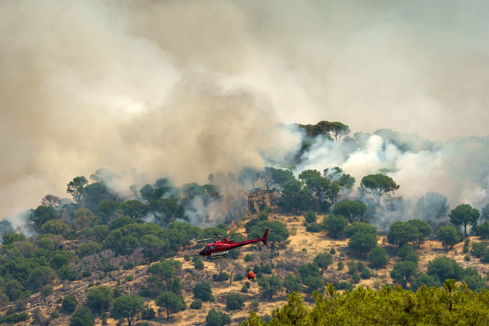 epa10082044 A firefighting helicopter flies over the fire in Cebreros Avila, Spain, 20 July 2022. The fire that started Saturday 17 has burned over 3,000 hectares so far.  EPA/RAUL SANCHIDRIAN