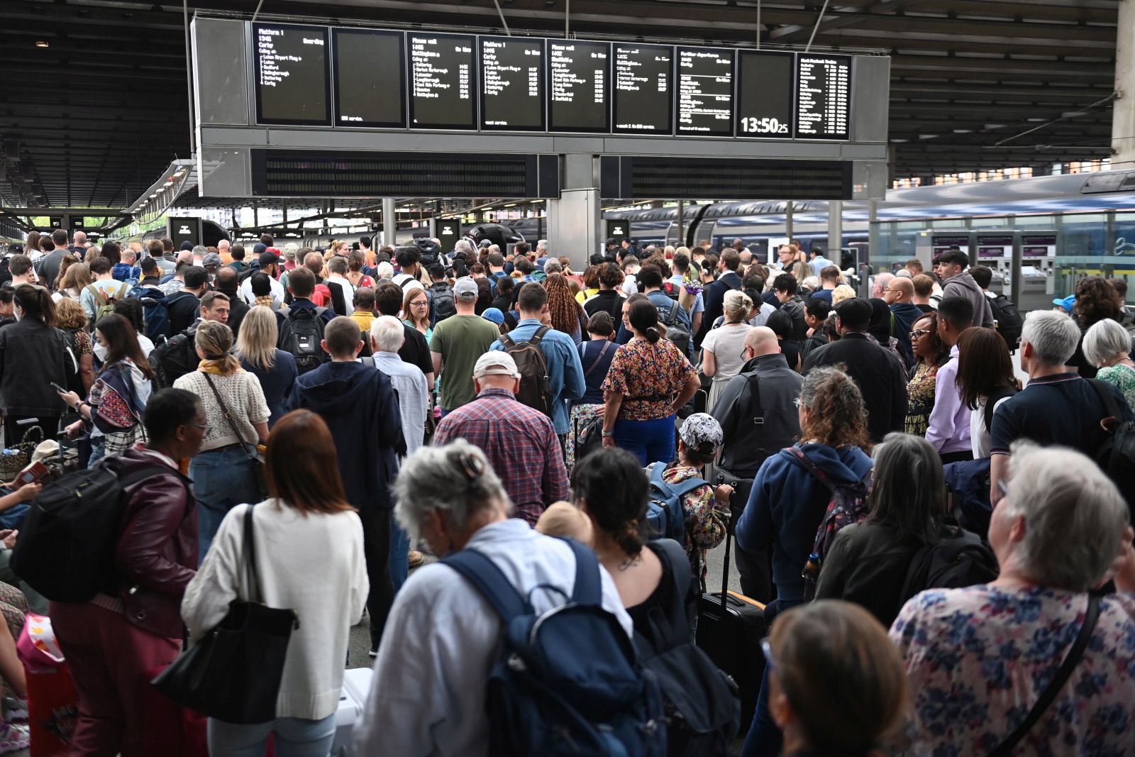 epa10092273 Travelers queue to board a train at St Pancras Station in London, Britain, 26 July 2022. The Rail Maritime and Transport Workers union (RMT) has organized 24-hour strikes for 27 and 30 July over a pay dispute. The strike is expected to include 40,000 workers including signaling and track maintenance workers and 14 train operating companies.  EPA/NEIL HALL