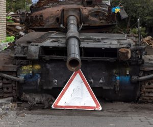 epa10080456 A cat runs past a Ukrainian tank that was destroyed during Russian attacks, in Hostomel, Ukraine, 19 July 2022. Hostomel, Irpin as well as other towns and villages in the northern part of the Kyiv region became battlefields and were heavily shelled when Russian troops tried to reach the Ukrainian capital Kyiv in February and March 2022. Russian troops on 24 February entered Ukrainian territory, starting a conflict that has provoked destruction and a humanitarian crisis.  EPA/ROMAN PILIPEY