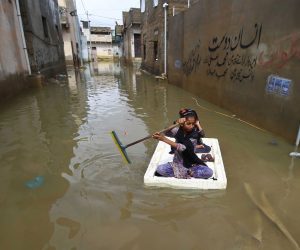 epa10092118 Children make their way through a flooded area after heavy monsoon rains in Karachi, Pakistan, 26 July 2022. Heavy rains have claimed 304 lives so far in Pakistan during the current monsoon season.  EPA/SHAHZAIB AKBER