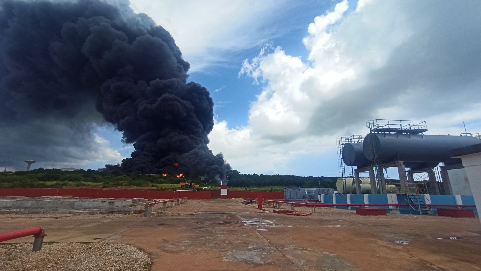 epa10109189 A column of smoke generated by the fire in a fuel depot in Matanzas, Cuba, 06 August 2022. According to a Cuban Presidency report, some 17 firefighters went missing while battling the fire in a petroleum deposit.  EPA/Ernesto Mastrascusa