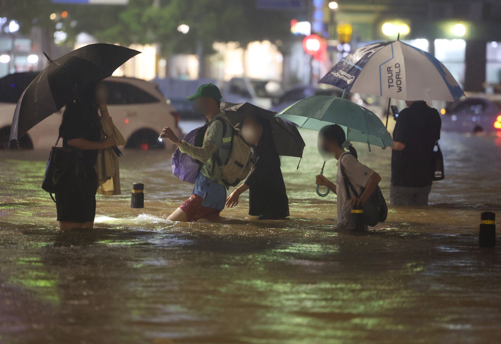 epa10112000 People wade though an inundated road in southern Seoul, South Korea, 08 August 2022 (issued 09 August 2022), as heavy rainfall of over 100 millimeters per hour, the heaviest in 80 years, battered Seoul and surrounding areas.  EPA/YONHAP SOUTH KOREA OUT