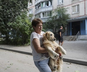 epa10122499 A local woman carries her dog to save its paws from fragments of broken glass after a shelling of a residential building in Kharkiv, Ukraine, 15 August 2022 amid Russia's military invasion. Five people were injured in a result of the shelling, the Ukrainian Rescue Service has reported. Kharkiv and surrounding areas have been the target of heavy shelling since February 2022, when Russian troops entered Ukraine starting a conflict that has provoked destruction and a humanitarian crisis.  EPA/VASILIY ZHLOBSKY