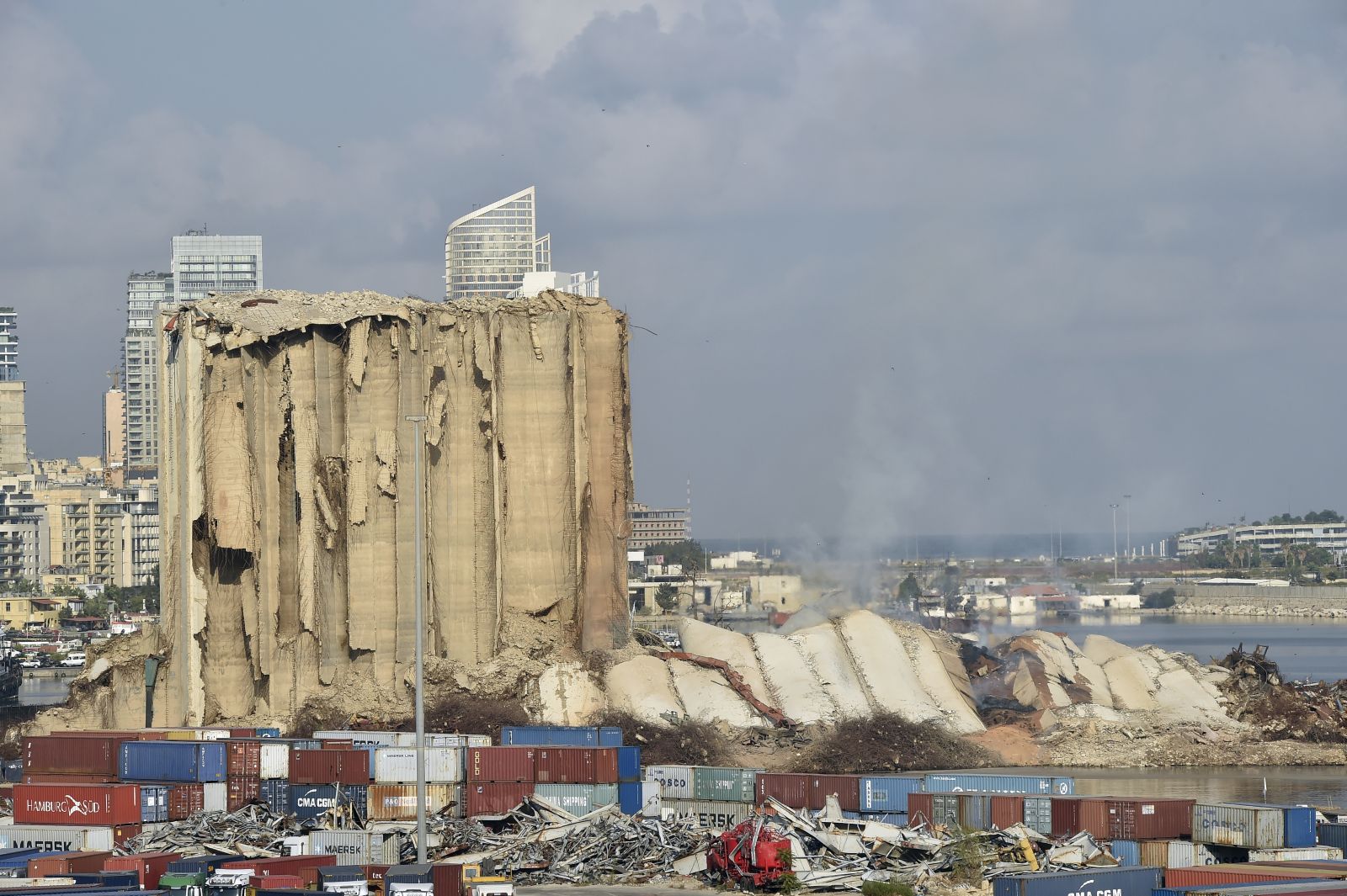 epa10134208 Dust rises after a section of the wheat silos collapsed at the Port of Beirut, Lebanon, 23 August 2022. The Beirut Port wheat silos, damaged by the Beirut Port blast of 2020, began to collapse on 31 July 2022, while another part came down on 04 August, on the second anniversary of the explosion. A third section collapsed on 23 August 2022.  EPA/WAEL HAMZEH