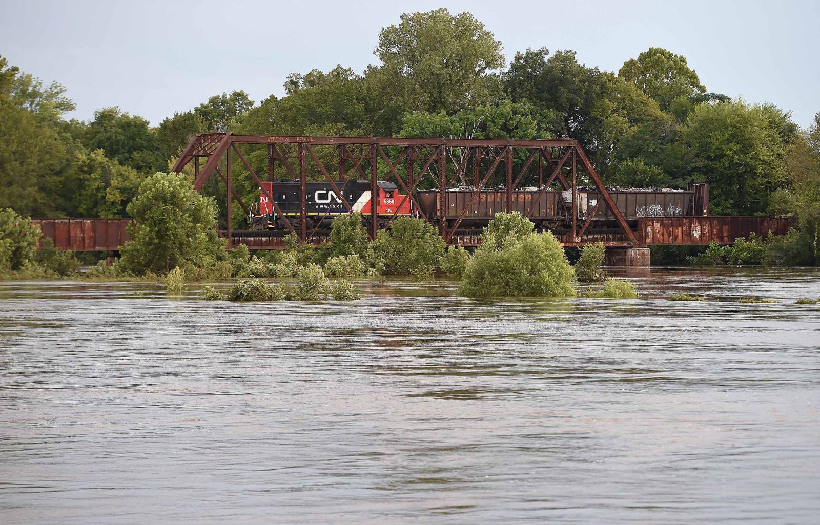 epa10148788 A freight train crosses the Pearl River in Jackson, Mississippi, USA, 30 April 2022. Flood waters from the Pearl River have flooded areas of Jackson and damaged the city's primary water treatment facility. According to reports as many as 180,000 residents are without running water for cleaning, cooking, drinking and flushing toilets.  EPA/CHRIS TODD