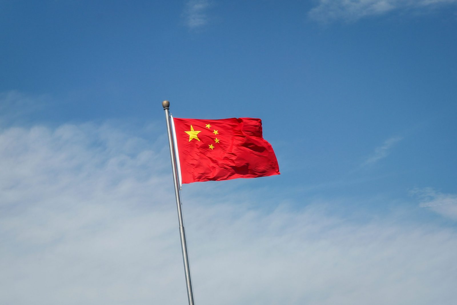 epa10133364 China's flag flutters along a road in Beijing, China, 22 August 2022. China has cut its benchmark loan rates to help revive its economy. China's one year loan prime rate was cut from 3.7 percent to 3.65 percent, while the loan rates for mortgages were cut from 4.45 percent to 4.3 percent, the People's Bank of China (PBOC) said.  EPA/MARK R. CRISTINO