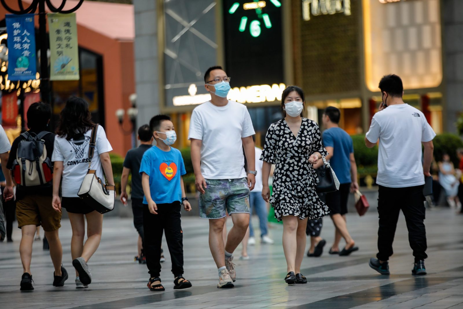 epa10146963 People wearing face masks walk around Jiefangbei pedestrian street in Chongqing, China, 30 August 2022. Local authorities implemented tighter COVID-19 restrictions after 11 cases were detected in Chongqing, by imposing mass testing and establishing temporary control areas.  EPA/WU HAO