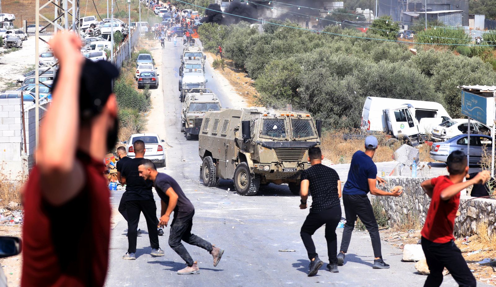 epa10146954 Palestinians hurl stones at Israeli troops during an Israeli operation to arrest Palestinian militants at Rojeeb village near the West Bank city of Nablus, 30 August 2022. Two Palestinian militants were arrested and another 50 were wounded during the opearation.  EPA/ALAA BADARNEH