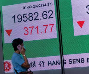 epa10151600 A woman walks past a billboard showing the Hang Seng Index in Hong Kong, China, 01 September 2022. The Hang Seng Index fell two percent, the lowest since August 24, amid renewed concerns about worsening cross-strait tensions.  EPA/JEROME FAVRE