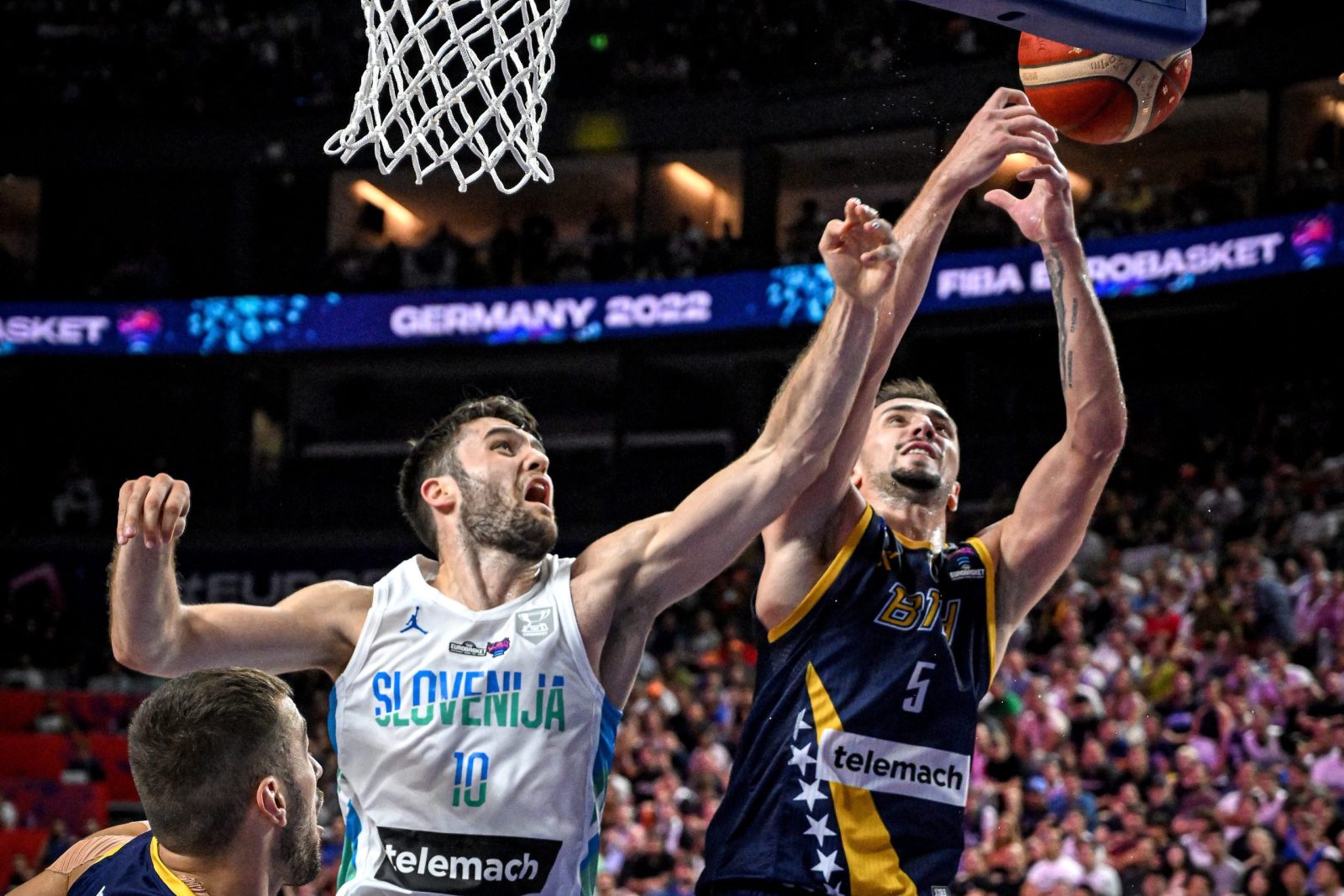 epa10159820 Mike Tobey of Slovenia (L) in action against  Edin Atic of Bosnia and Herzegovina (R) during the FIBA EuroBasket 2022 group B stage match between Bosnia and Herzegovina and Slovenia in Cologne, Germany, 04 September 2022.  EPA/SASCHA STEINBACH