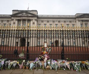 epa10172528 Floral tributes outside the railings of Buckingham Palace a day after the passing of Queen Elizabeth II, in London, Britain, 09 September 2022. Britain's Queen Elizabeth II died at her Scottish estate on 08 September 2022. The 96-year-old queen was the longest-reigning monarch in British history.  EPA/NEIL HALL