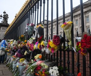 epa10172521 Floral tributes hang from the railings of Buckingham Palace a day after the passing of Queen Elizabeth II, in London, Britain, 09 September 2022. Britain's Queen Elizabeth II died at her Scottish estate on 08 September 2022. The 96-year-old queen was the longest-reigning monarch in British history.  EPA/NEIL HALL