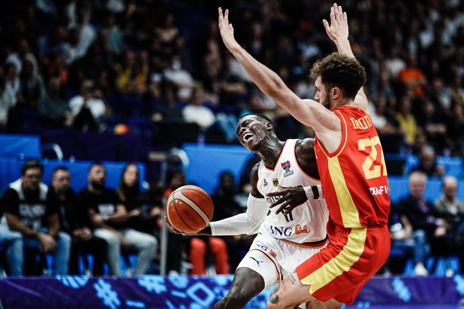 epa10175894 Germany's Dennis Schroeder (L) in action against Montenegro's Igor Drobnjak (R) during the FIBA EuroBasket 2022 round of 16 match between Germany and Montenegro at EuroBasket Arena in Berlin, Germany, 10 September 2022.  EPA/CLEMENS BILAN