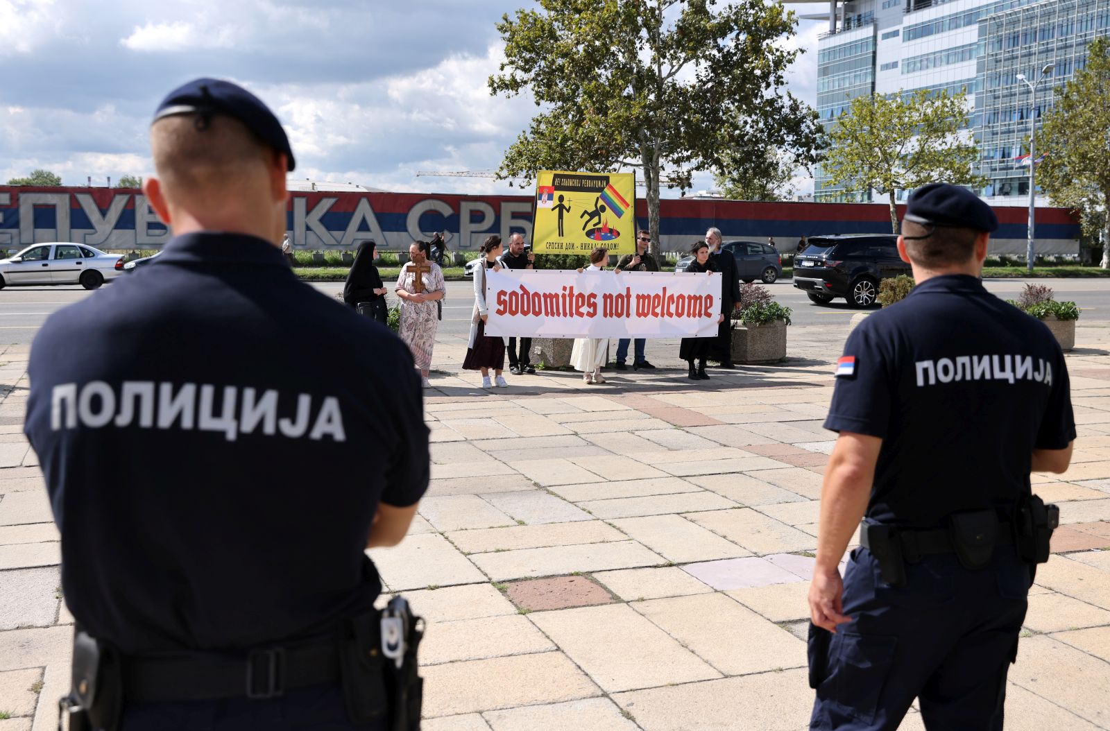 epa10179677 Police officers stand guard as anti-LGBT protestors hold banners during the opening ceremony of the EuroPride 2022 in Belgrade, Serbia, 12 September 2022. EuroPride, a pan-European international event dedicated to LGBTQ pride, is hosted by a different European city each year. Serbia's capital Belgrade is supposed to host the event on the 17 September 2022. But according to country leaders, citing threats from right-wing extremist groups and fears of clashes, the final decision on whether the event will be held has not been confirmed.  EPA/ANDREJ CUKIC