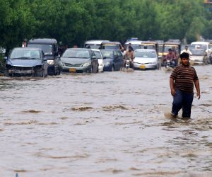epa10181582 People make their way through a flooded area following heavy rains in Karachi, Sindh province, Pakistan, 13 September 2022. According ?to disaster management authorites, around 160 bridges and 5,000 km (3,200 miles) of roads have been destroyed or damaged, 3.5 million acres of crops af?fected and about 800,000 livestock lost. Flash floods triggered by heavy monsoon rains have killed over 1,200 people across Pakistan since mid-June 20?22. More than 33 million people have been affected by floods, the country's climate change minister Sherry Rehman said.  EPA/SHAHZAIB AKBER