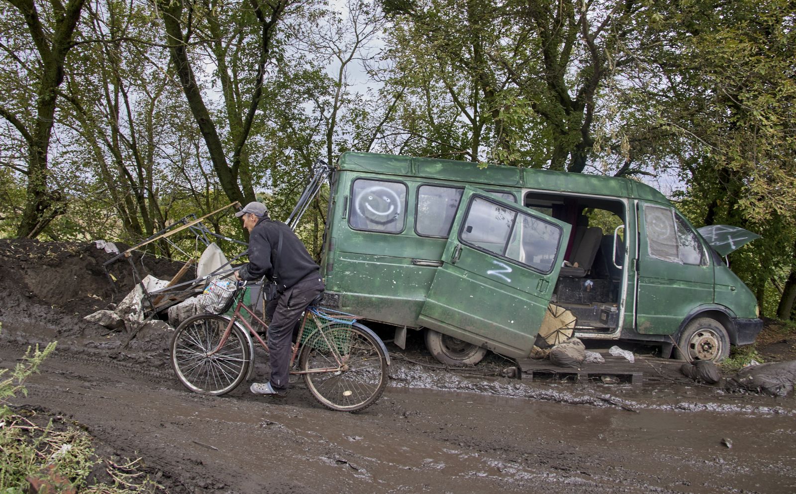 epa10182258 A local man rides a bicycle past a damaged car with the Z symbol on a road near the recently recaptured city of Balakliia in Kharkiv's area, Ukraine, 13 September 2022. The Ukrainian army pushed Russian troops from occupied territory in the northeast of the country in a counterattack. Kharkiv and surrounding areas have been the target of heavy shelling since February 2022, when Russian troops entered Ukraine starting a conflict that has provoked destruction and a humanitarian crisis.  EPA/SERGEY KOZLOV