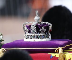 epa10183597 The Imperial State Crown lays on top of the coffin containing the body of Britain's late Queen Elizabeth II, draped in the royal standard, as it is transported on a gun carriage of the King's Troop Royal Horse Artillery from Buckingham Palace to Westminster Hall followed by members of the royal family in London, Britain, 14 September 2022. After a short service, the queen's lying in state will begin, lasting for four days and ending on the morning of the state funeral on the 19 September.  EPA/YOAN VALAT