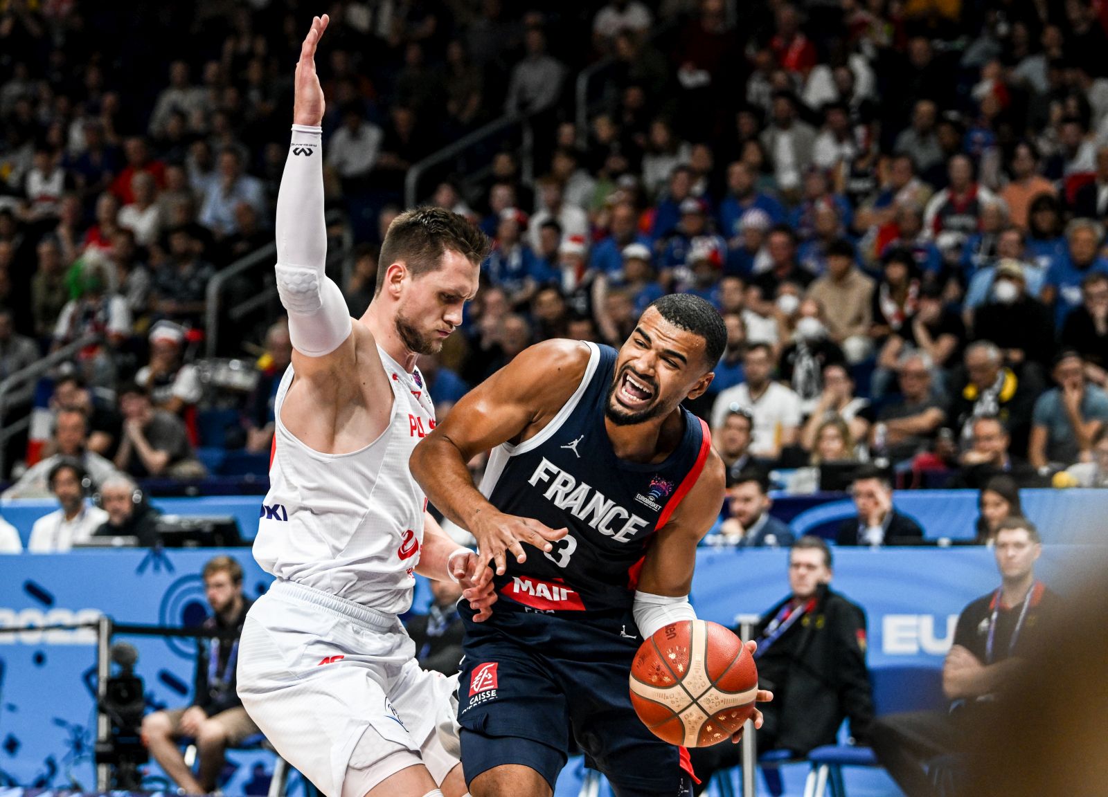 epa10188346 Mateusz Ponitka (L) of Poland in action against Timothe Luwawu-Cabarrot (R) of France during the FIBA EuroBasket 2022 semi final match between Poland and France at EuroBasket Arena in Berlin, Germany, 16 September 2022.  EPA/FILIP SINGER