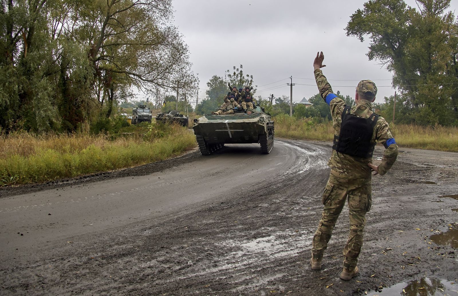 epa10188441 A Ukrainian serviceman waves at his comrades riding an armoured personnel carrier (APC) near the urban settlement of Kazachya Lopan, north of Kharkiv, northeastern Ukraine, 16 September 2022, amid Russia's invasion. The Ukrainian army pushed Russian troops from occupied territory in the northeast of the country in a counterattack. Kharkiv and surrounding areas have been the target of heavy shelling since February 2022, when Russian troops entered Ukraine starting a conflict that has provoked destruction and a humanitarian crisis.  EPA/SERGEY KOZLOV