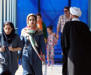 epa10193159 Iranian women walk past next to a cleric in a street, in Tehran, Iran, 19 September 2022. Mahsa Amini, a 22 year old girl, was detained on 13 September by the police unit responsible for enforcing Iran's strict dress code for women. Amini was declared dead on 16 September, after she spent 3 days in a coma. Protests broke out in Saqez, hometown of Amini during her funeral on 17 September.  EPA/ABEDIN TAHERKENAREH