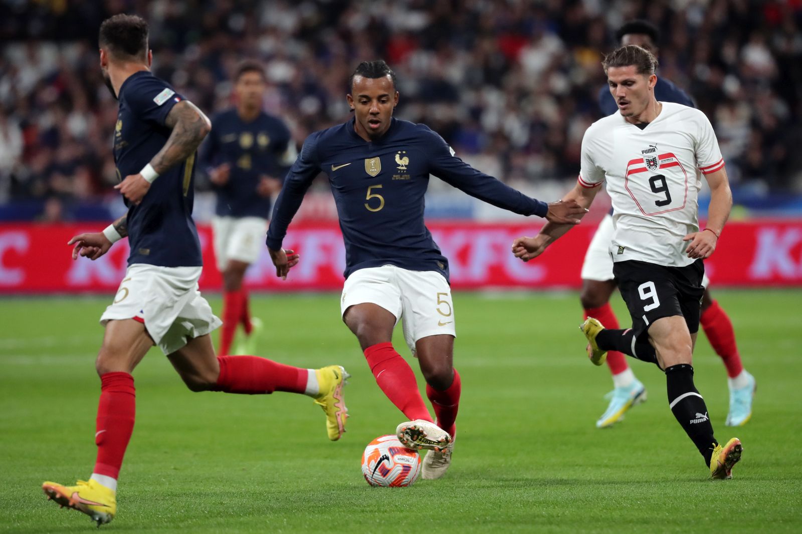 epa10199791 Jules Kounde (C) of France in action against Marcel Sabitzer (R) of Austria during the UEFA Nations League match between France and Austria in Saint-Denis, France, 22 September 2022.  EPA/CHRISTOPHE PETIT TESSON