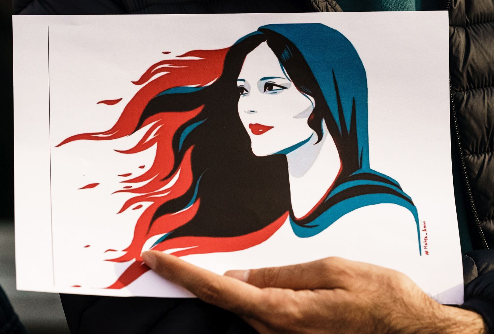 epa10201920 A participant holds an illustration showing Mahsa Amini during a rally in Berlin, Germany, 23 September 2022. Iran has faced many anti-government protests following the death of Mahsa Amini, a 22-year-old Iranian woman, who was arrested in Tehran on 13 September by the morality police, a unit responsible for enforcing Iran's strict dress code for women. She fell into a coma while in police custody and was declared dead on 16 September, with the authorities saying she died of a heart failure while her family advising that she had no prior health conditions. Her death has triggered protests in various areas in Iran and around the world. According to Iran's state news agency IRNA, Iranian President Ebrahim Raisi expressed his sympathy to the family of Amini on a phone call and assured them that her death will be investigated carefully. Chief Justice of Iran Gholam-Hossein Mohseni-Eje'i assured her family that upon its conclusion, the investigation results by the Iranian Legal Medicine Organization will be announced without any special considerations.  EPA/CLEMENS BILAN