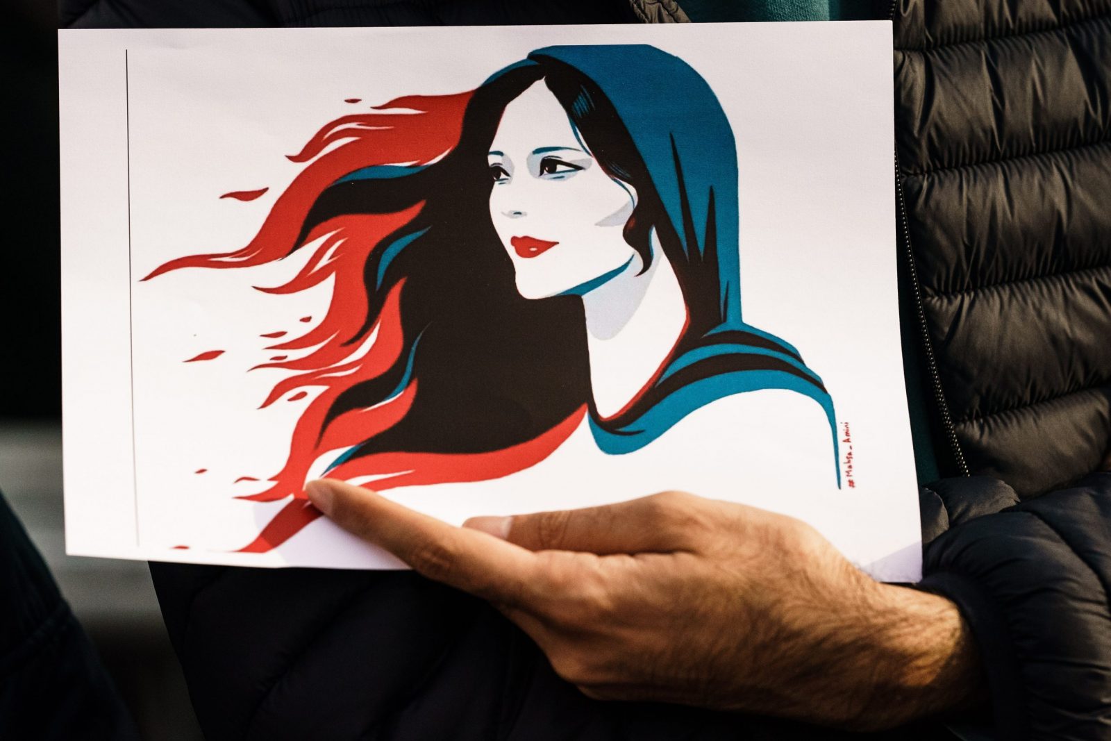 epa10201920 A participant holds an illustration showing Mahsa Amini during a rally in Berlin, Germany, 23 September 2022. Iran has faced many anti-government protests following the death of Mahsa Amini, a 22-year-old Iranian woman, who was arrested in Tehran on 13 September by the morality police, a unit responsible for enforcing Iran's strict dress code for women. She fell into a coma while in police custody and was declared dead on 16 September, with the authorities saying she died of a heart failure while her family advising that she had no prior health conditions. Her death has triggered protests in various areas in Iran and around the world. According to Iran's state news agency IRNA, Iranian President Ebrahim Raisi expressed his sympathy to the family of Amini on a phone call and assured them that her death will be investigated carefully. Chief Justice of Iran Gholam-Hossein Mohseni-Eje'i assured her family that upon its conclusion, the investigation results by the Iranian Legal Medicine Organization will be announced without any special considerations.  EPA/CLEMENS BILAN