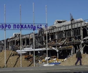 epa10206236 A man walks by a destroyed building near a sign reading 'Welcome', in Mariupol, eastern Ukraine, 25 September 2022. From 23 to 27 September, residents of the self-proclaimed Luhansk and Donetsk People's Republics as well as the Russian-controlled areas of the Kherson and Zaporizhzhia regions of Ukraine vote in a referendum to join the Russian Federation. On 24 February 2022 Russian troops entered the Ukrainian territory in what the Russian president declared a 'Special Military Operation', starting an armed conflict that has provoked destruction and a humanitarian crisis.  EPA/STRINGER