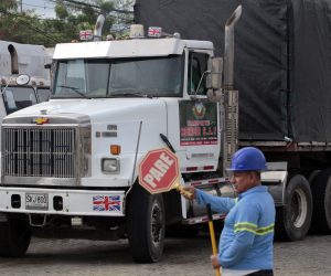 epa10207781 A worker directs traffic in front of a truck that will cross into Venezuela on the Simon Bolivar international bridge, in Cucuta, Colombia, 26 September 2022. Four trucks loaded with medical materials and other products will be the first to cross the bridge as the border between Colombia and Venezuela reopens after seven years.  EPA/Mario Caicedo