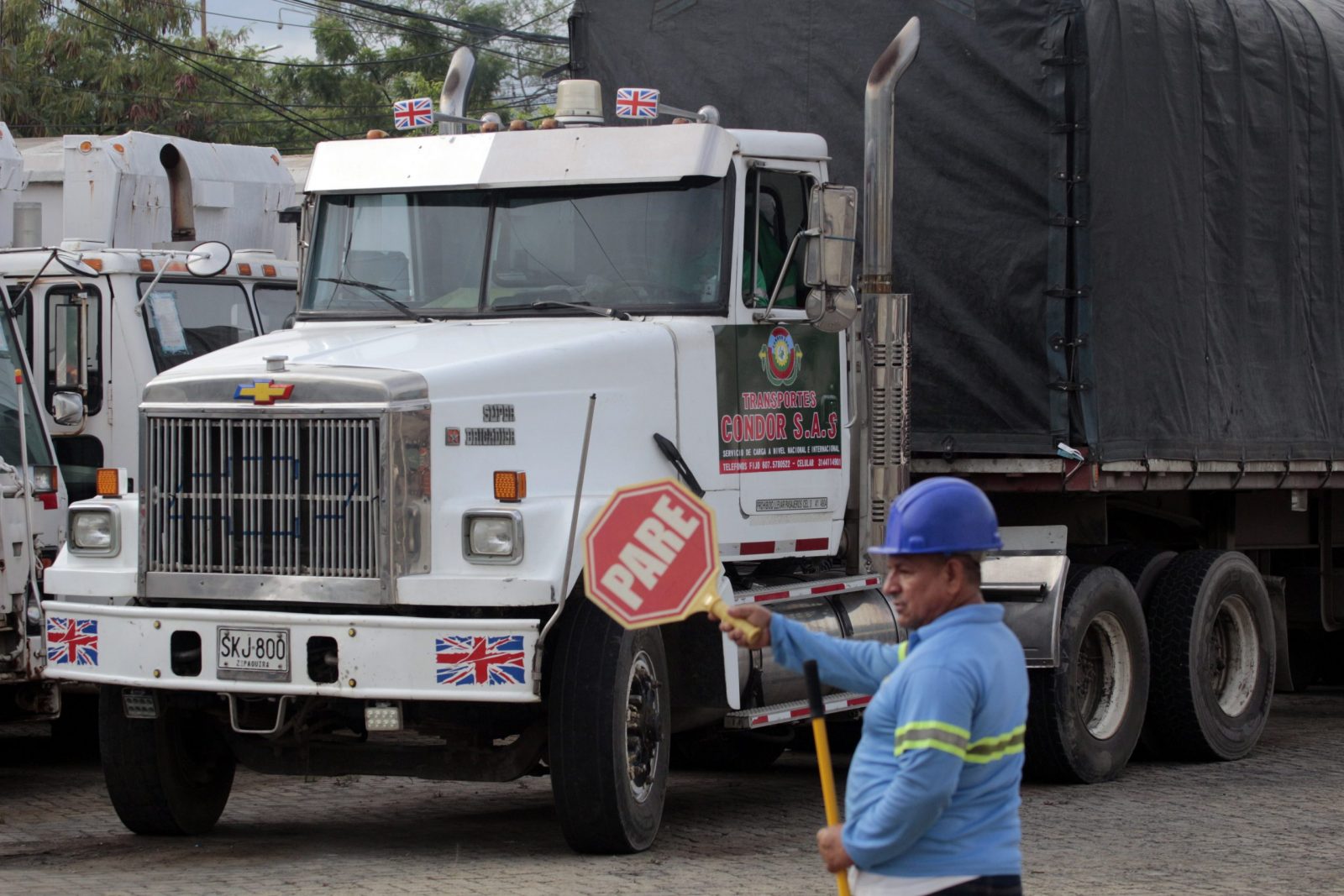 epa10207781 A worker directs traffic in front of a truck that will cross into Venezuela on the Simon Bolivar international bridge, in Cucuta, Colombia, 26 September 2022. Four trucks loaded with medical materials and other products will be the first to cross the bridge as the border between Colombia and Venezuela reopens after seven years.  EPA/Mario Caicedo