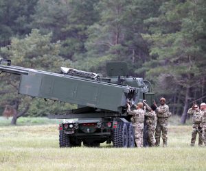 epa10207730 U.S. servicemen with their light multiple rocket launcher M142 High Mobility Artillery Rocket System (HIMARS) attend the military exercise 'Namejs 2022' at Skede polygon near Liepaja, Latvia, 26 September 2022. The goal of this exercise is to demonstrate the effective multicomponent cooperation between the National Armed Forces and the US Armed Forces, with Latvian side discovering, identifying and evaluating the targets, and the allies providing the requested assistance and completing the mission objective.  EPA/TOMS KALNINS