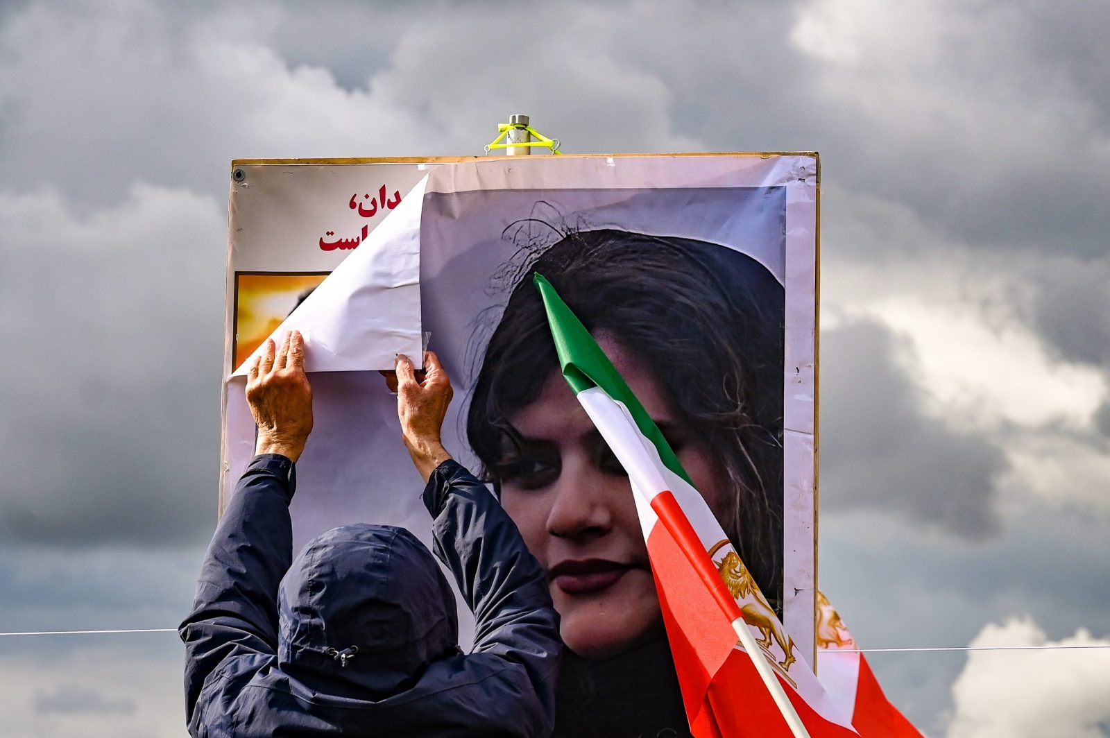 epa10211353 A participant prepares posters of Mahsa Amini during a rally in front of the Reichstag building in Berlin, Germany, 28 September 2022. Iran has been facing many anti-government protests following the death of Mahsa Amini, a 22-year-old Iranian woman, who was arrested in Tehran on 13 September by the morality police, a unit responsible for enforcing Iran's strict dress code for women and died while in their custody.  EPA/FILIP SINGER