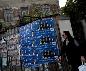 epa10213201 A woman walks past election posters in Dupnica, Bulgaria, 29 September 2022. The 2022 Bulgarian parliamentary election is scheduled for 02 November.  EPA/VASSIL DONEV