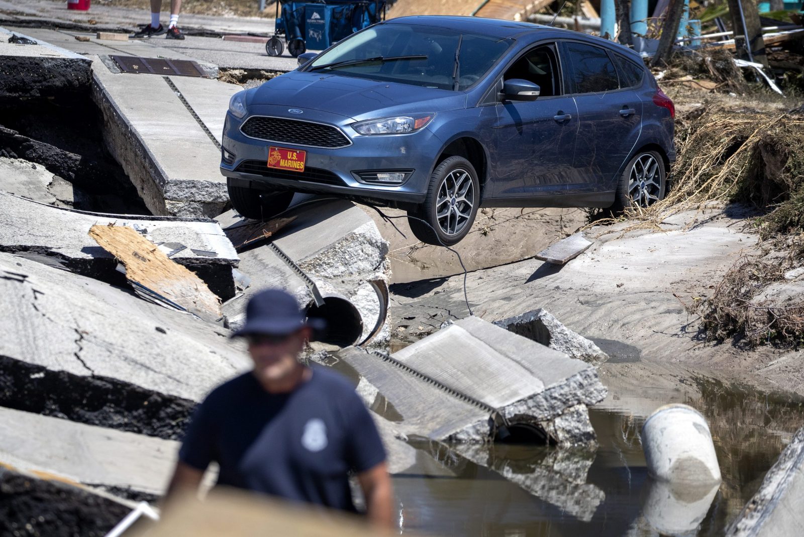 epa10216717 A car is perched on broken concrete in Matlacha Isles after the passing of Hurricane Ian, in Fort Myers Beach, Florida, USA, 30 September 2022. The category 4 hurricane made landfall on 28 September causing widespread damage and power outages.  EPA/CRISTOBAL HERRERA-ULASHKEVICH