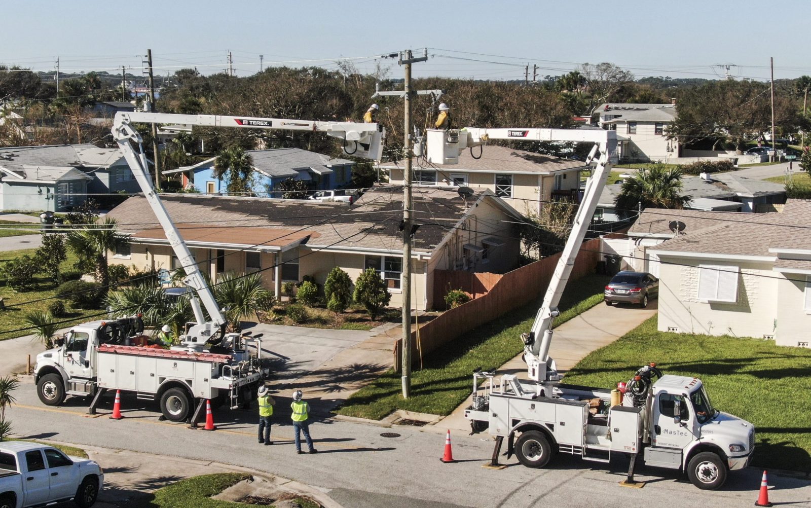 epa10219663 An aerial photo made with a drone shows linemen working to restore electricity in the wake of Hurricane Ian in Daytona Beach, Florida, 02 October 2022. The category 4 storm made land fall 28 September causing widespread damage and power outages.  EPA/TANNEN MAURY