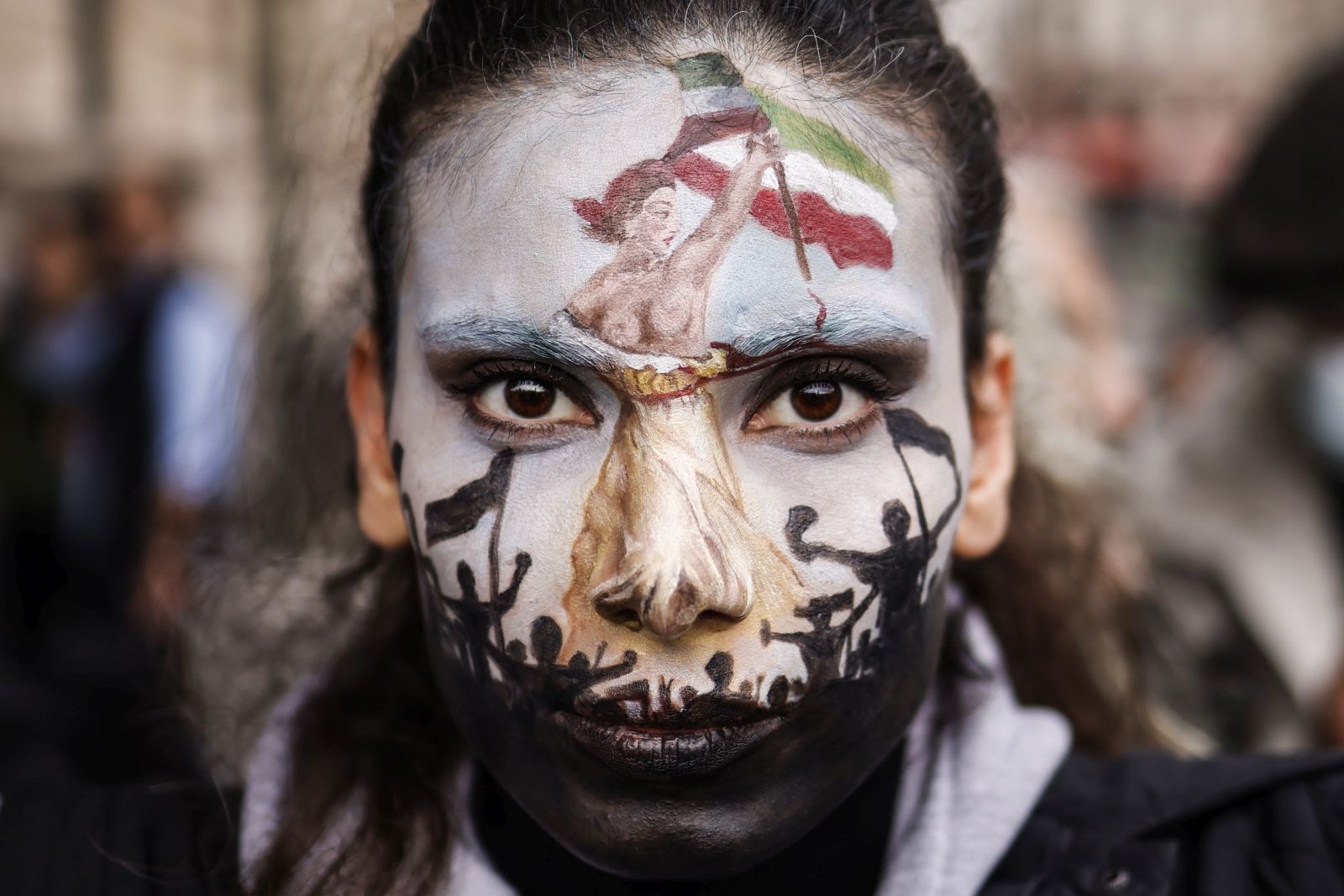 epa10219686 A woman with her face painted participates in a rally in support of Iranian women in Paris, France, 02 October 2022. This demonstration takes place following the deaths of Mahsa Amini, who died while in police custody after being detained by Iran's morality police, and Hadis Najafi, who was shot during a protest in Iran.  EPA/YOAN VALAT