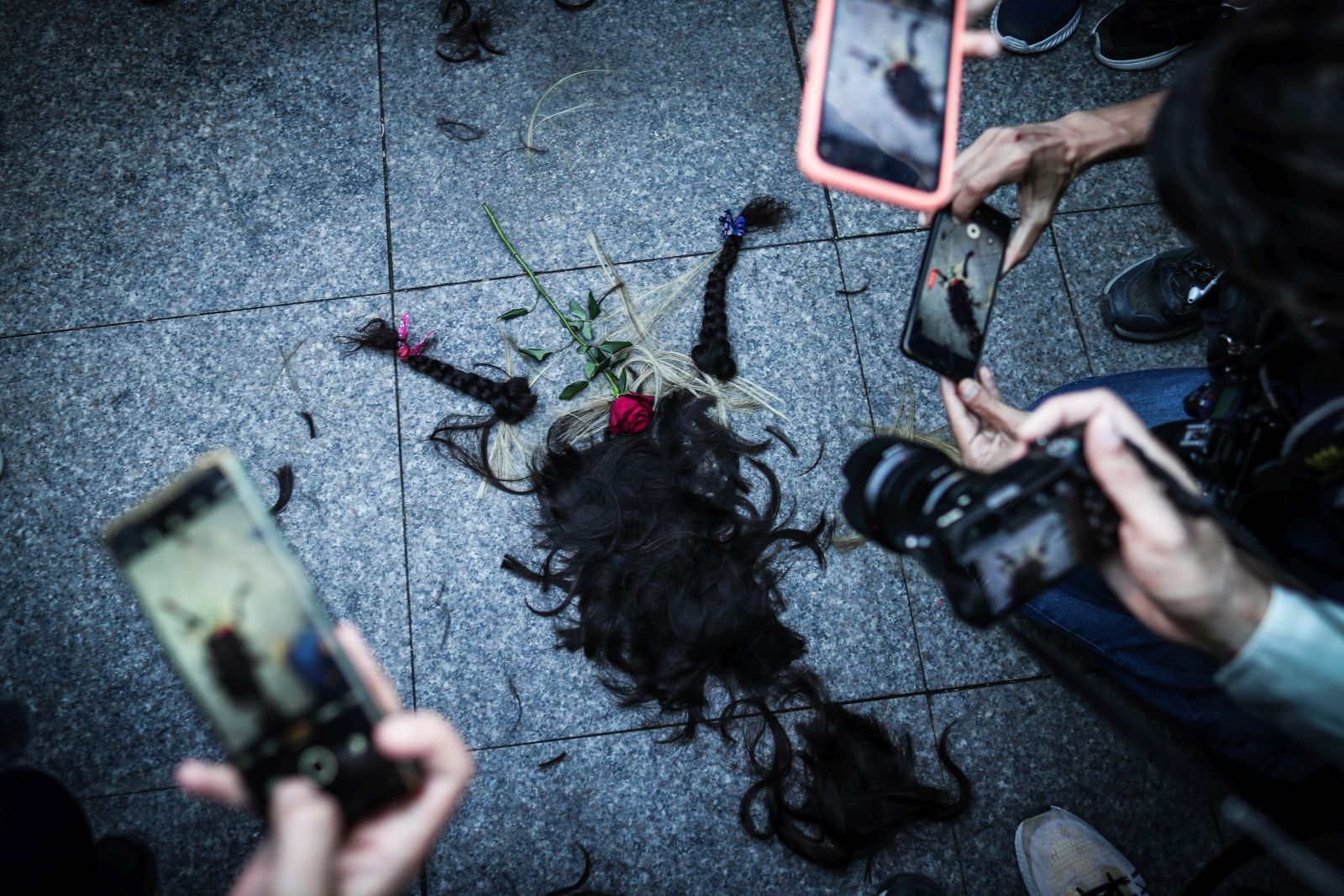 epa10219887 People take photos of a pile of hair cut by Iranian women during a protest following the death of Iranian Mahsa Amini, in Istanbul, Turkey, 02 October 2022. Amini, a 22-year-old Iranian woman, was arrested in Tehran on 13 September by the police unit responsible for enforcing Iran's strict dress code for women. She fell into a coma while in police custody and was declared dead on 16 September.  EPA/SEDAT SUNA