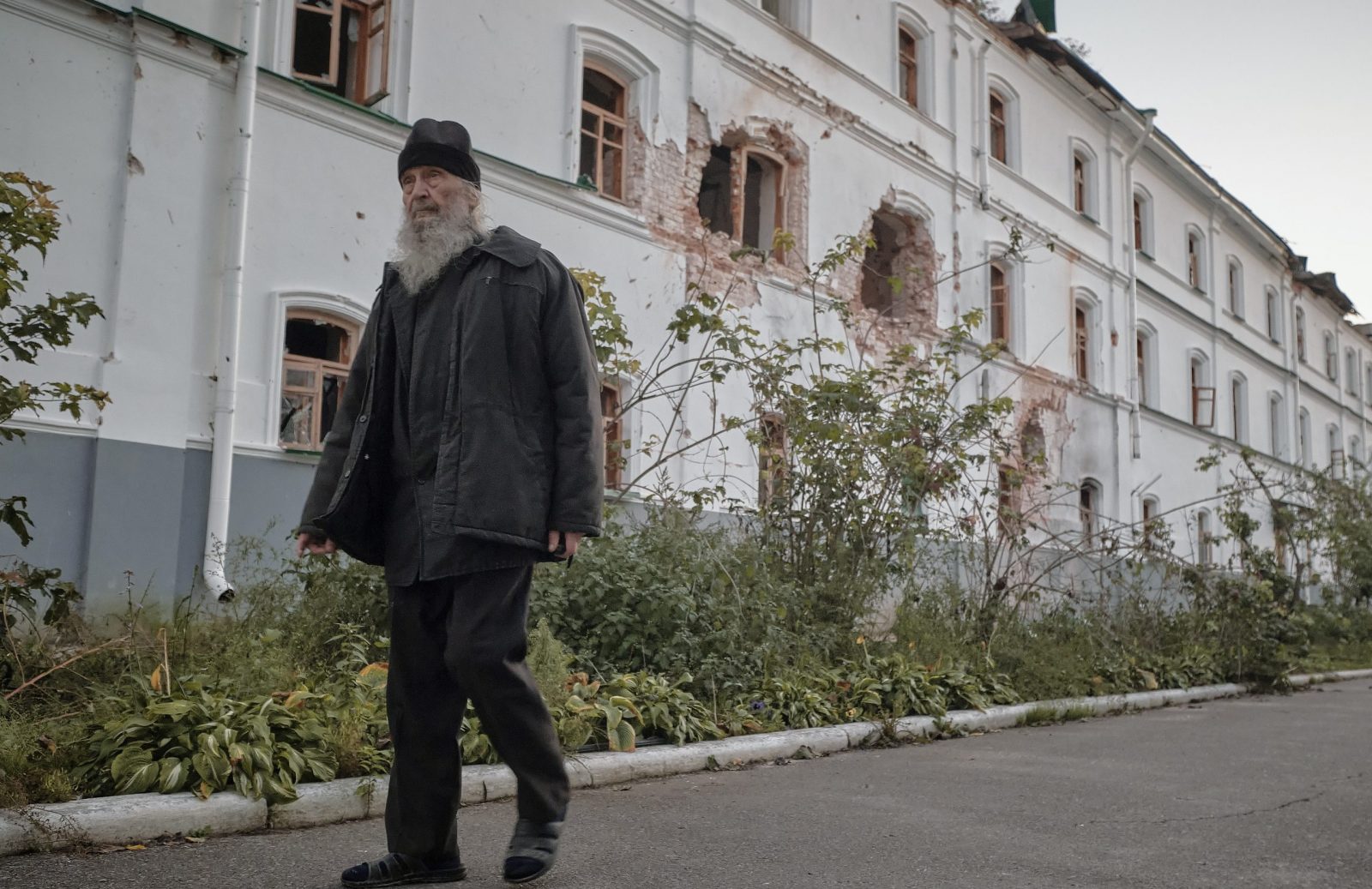 epa10222311 A monk walks past a damaged wall at the Sviatohirsk Lavra (cave monastery) in Sviatohirsk, Donetsk area, Ukraine, 03 October 2022 (issued 04 October 2022). Ukrainian forces recaptured the town of Sviatohirsk from Russian troops in September 2022. According to Ukrainian authorities, the major Orthodox Christian monastery of Sviatohirsk Lavra was damaged during Russian shelling on the town in June 2022. Russian troops entered Ukraine on 24 February 2022 starting a conflict that has provoked destruction and a humanitarian crisis.  EPA/YEVGEN HONCHARENKO